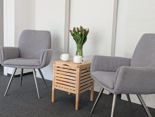 Zwei Sessel mit kleinem Tisch, Tulpen und zwei Tassen